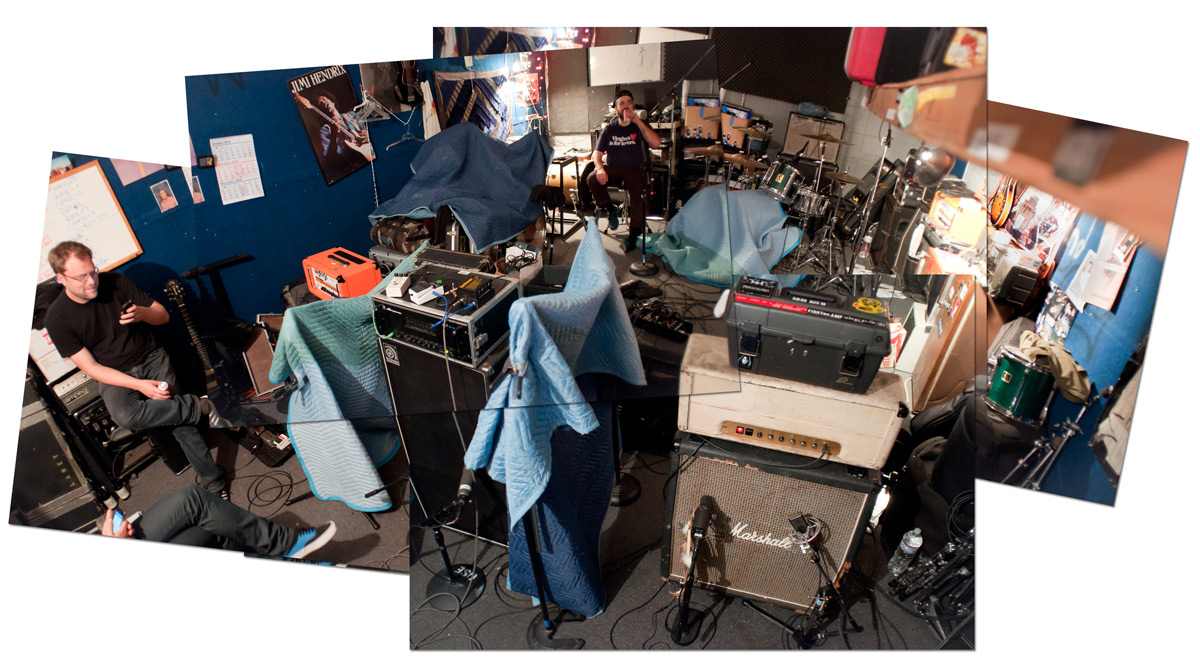 Kowloon Walled City pointing a wall of amps at an unsuspecting Macbook Pro.